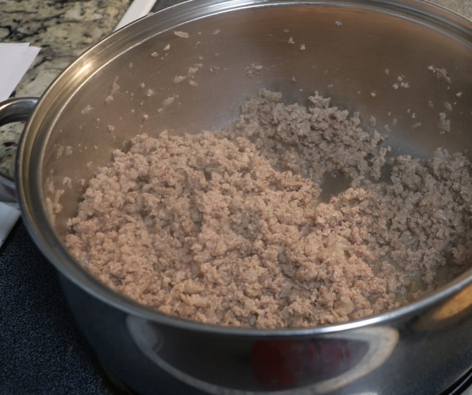 browned ground beef in a pan on the stove