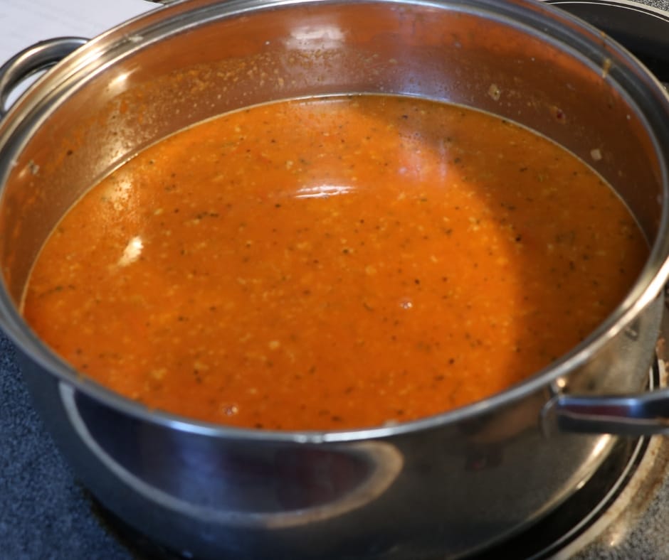 pan with spaghetti sauce ingredients, tomato sauce, ground beef, onions, garlic, italian seasoning and olive oil, getting ready to simmer to perfection