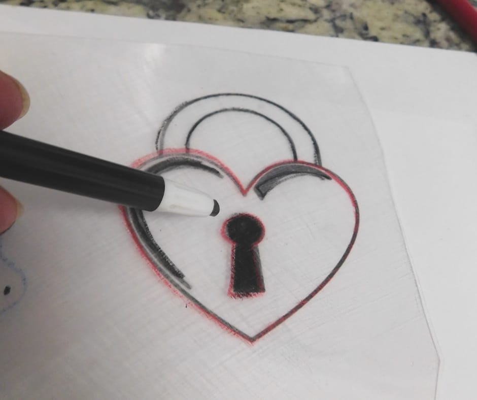 Tracing heart with crayon.