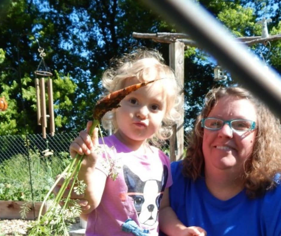child picking carrots, in the may garden