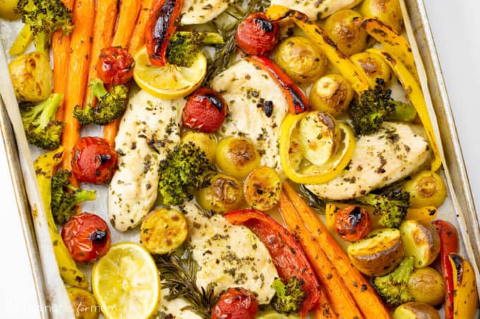 Sheet pan meal with chicken and roasted vegetables on pan.