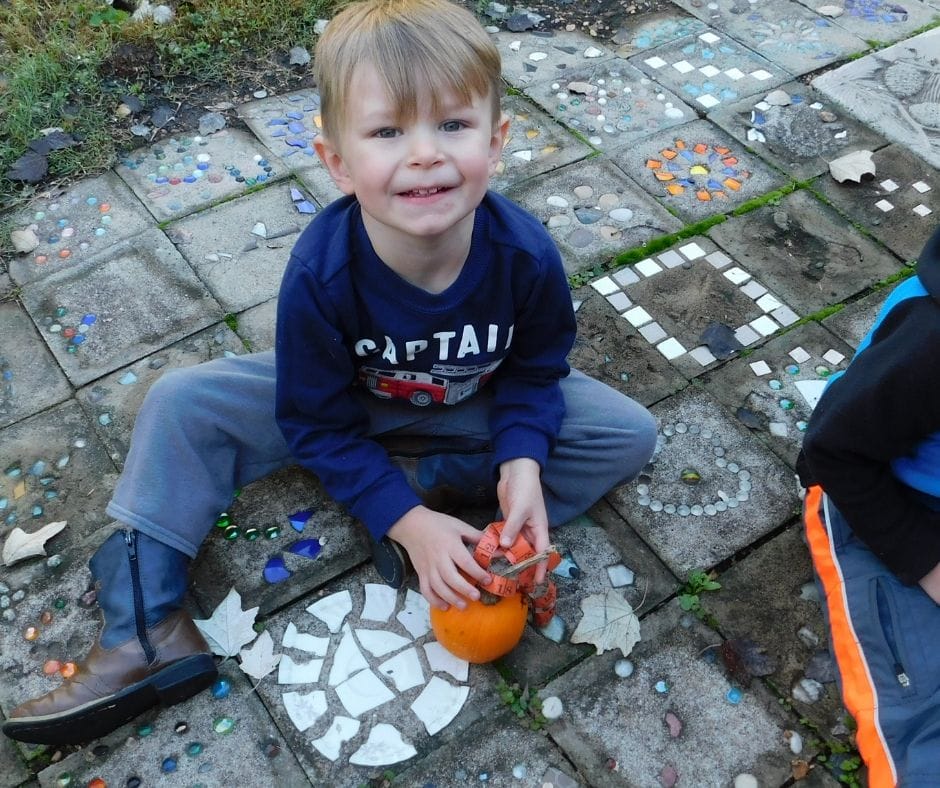 child measuring pumpkin with tape measure on the porch, pumpkin activities