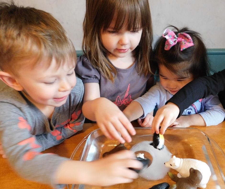 kids playing with ice and polar animals