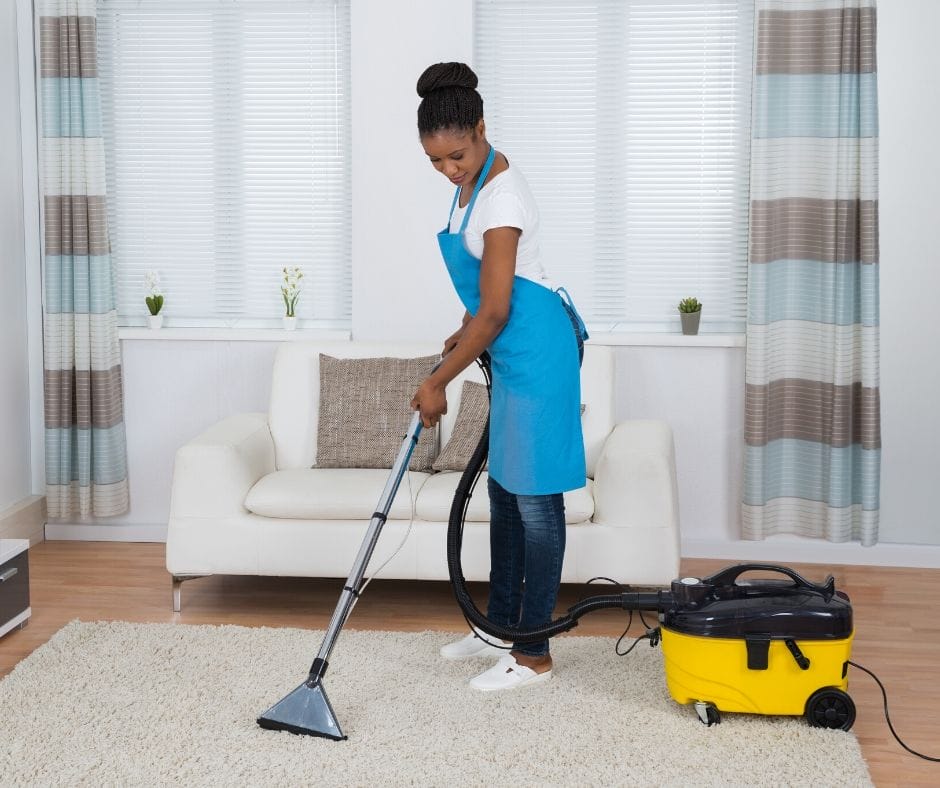 Home daycare provider vacuuming floors.