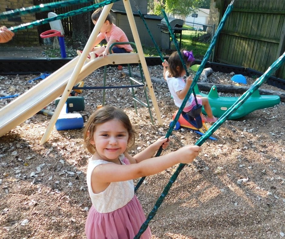 child sitting on a swing in the back yard