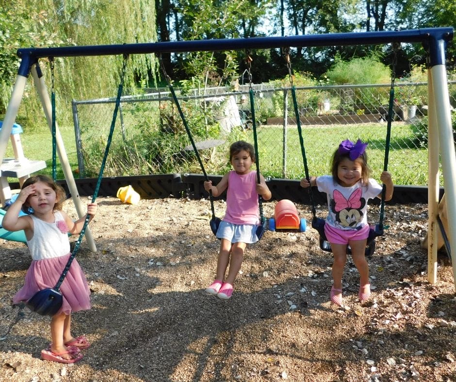 kids doing unstructured play swinging on the swing set