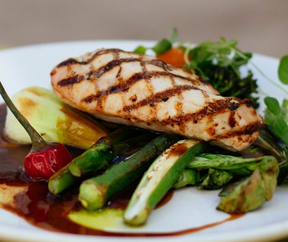 Chicken breast on top of vegetables on a plate for an easy dinner