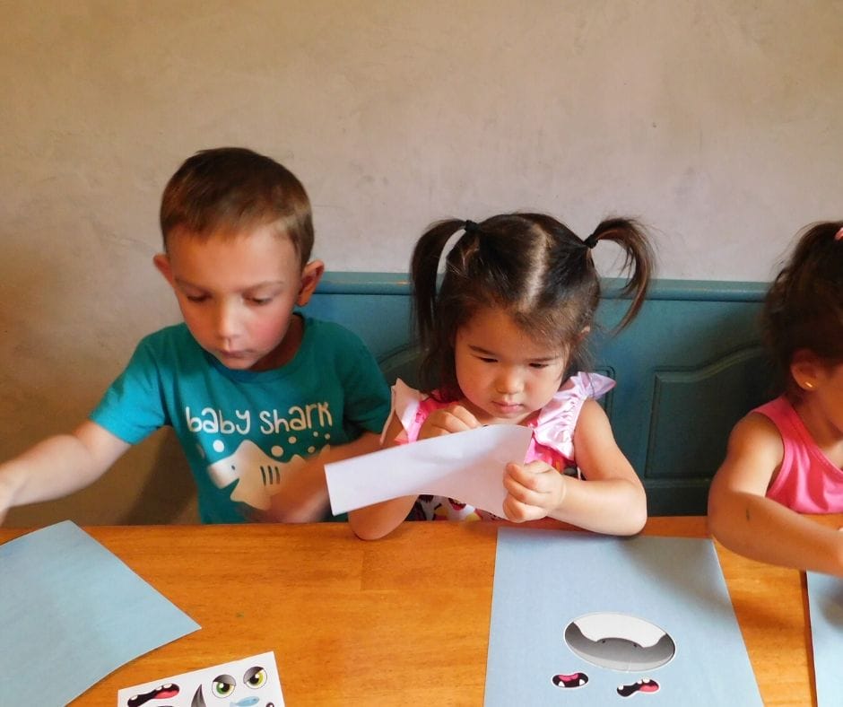 kids making shark faces with stickers