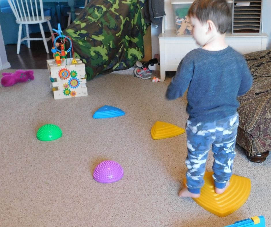 child jumping on plastic river stones in obstacle course