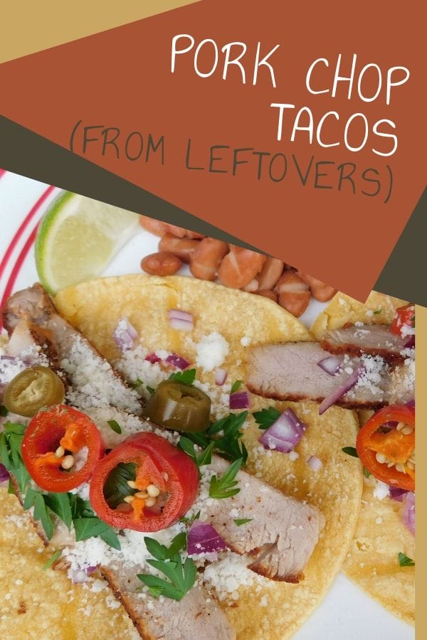 Pork chop tacos on a plate garnished with herbs, hot peppers, onions, and cotija cheese