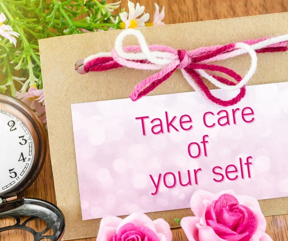 pink sign that says take care of yourself with pin flowers and a pink yarn bow