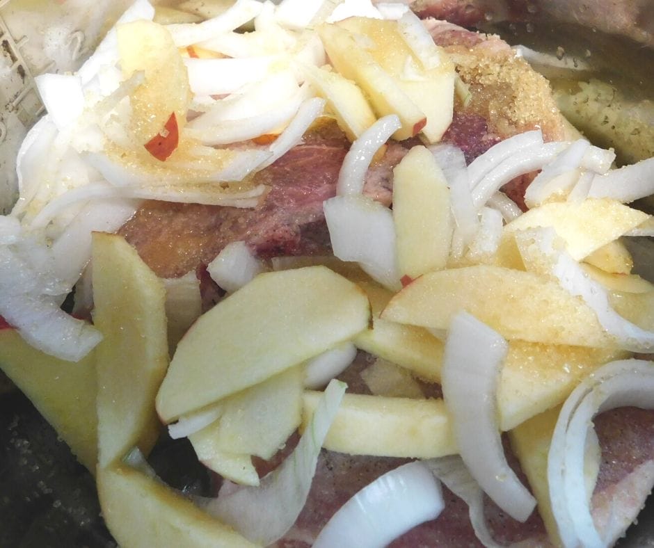 apples and onions on top of pork chops in the crock pot
