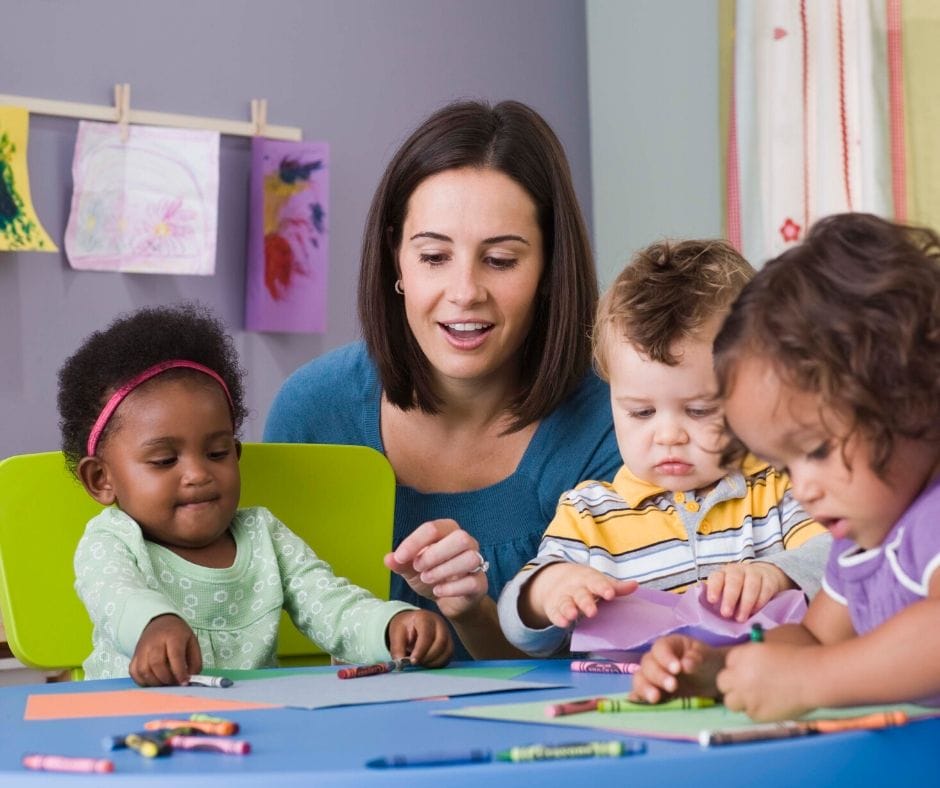 daycare provider drawing with kids at a table