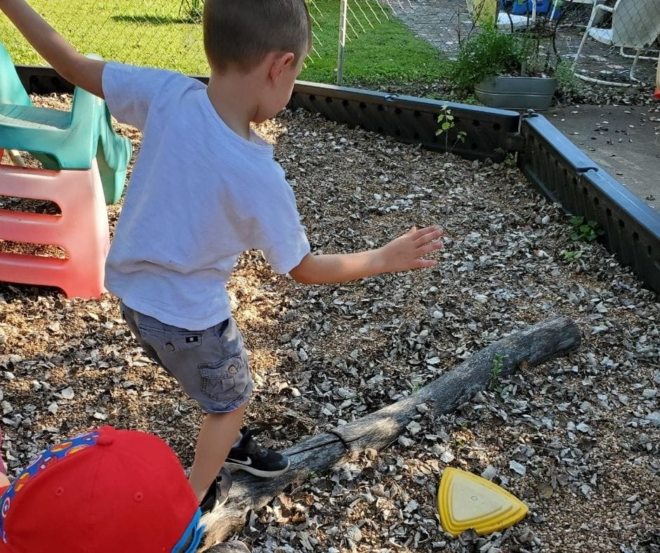 child balancing on logs