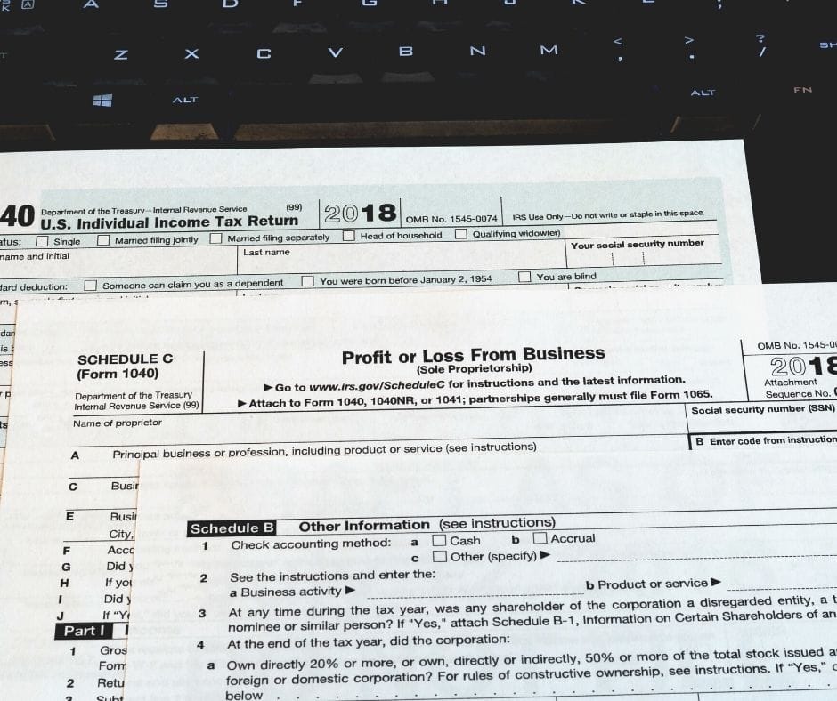 tax forms laying on a computer keyboard