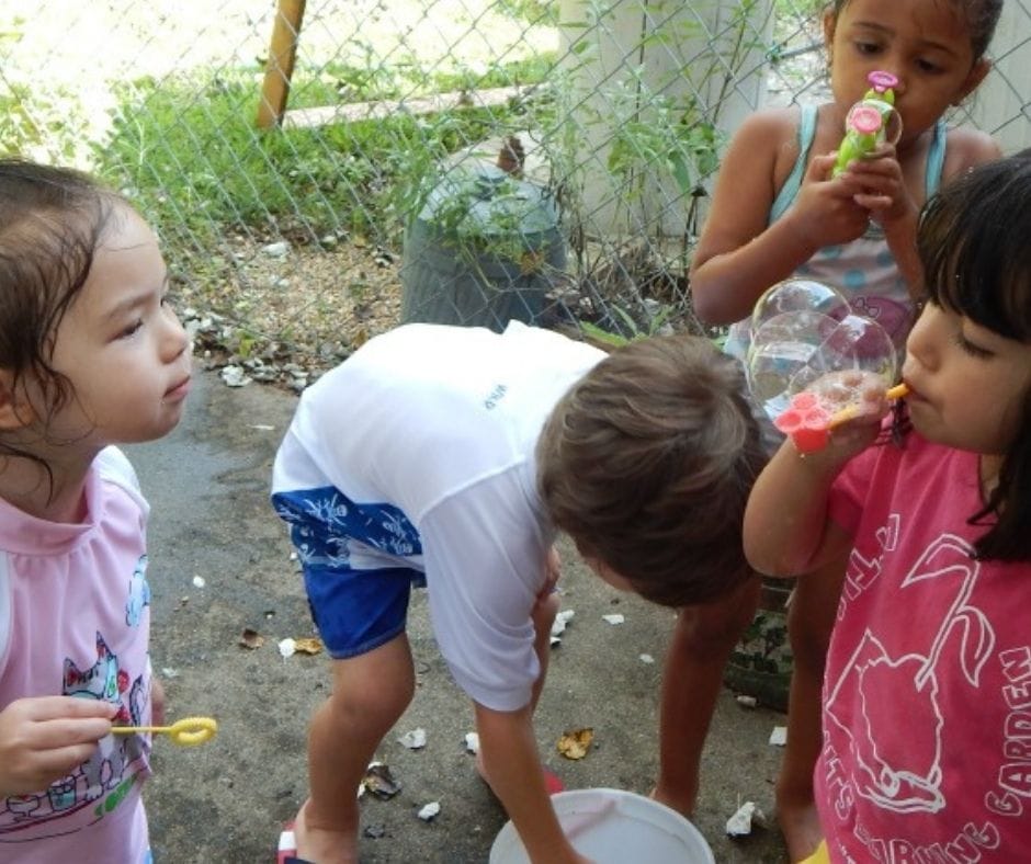 kids blowing bubbles at home daycare water party