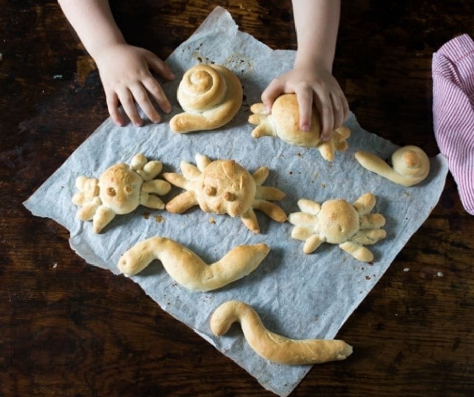 kids picking up bread they shaped and cooked