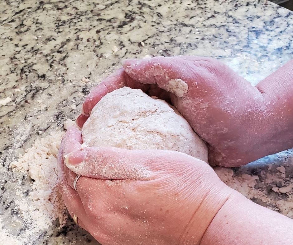 hands kneading grandma's old fashioned biscuit dough