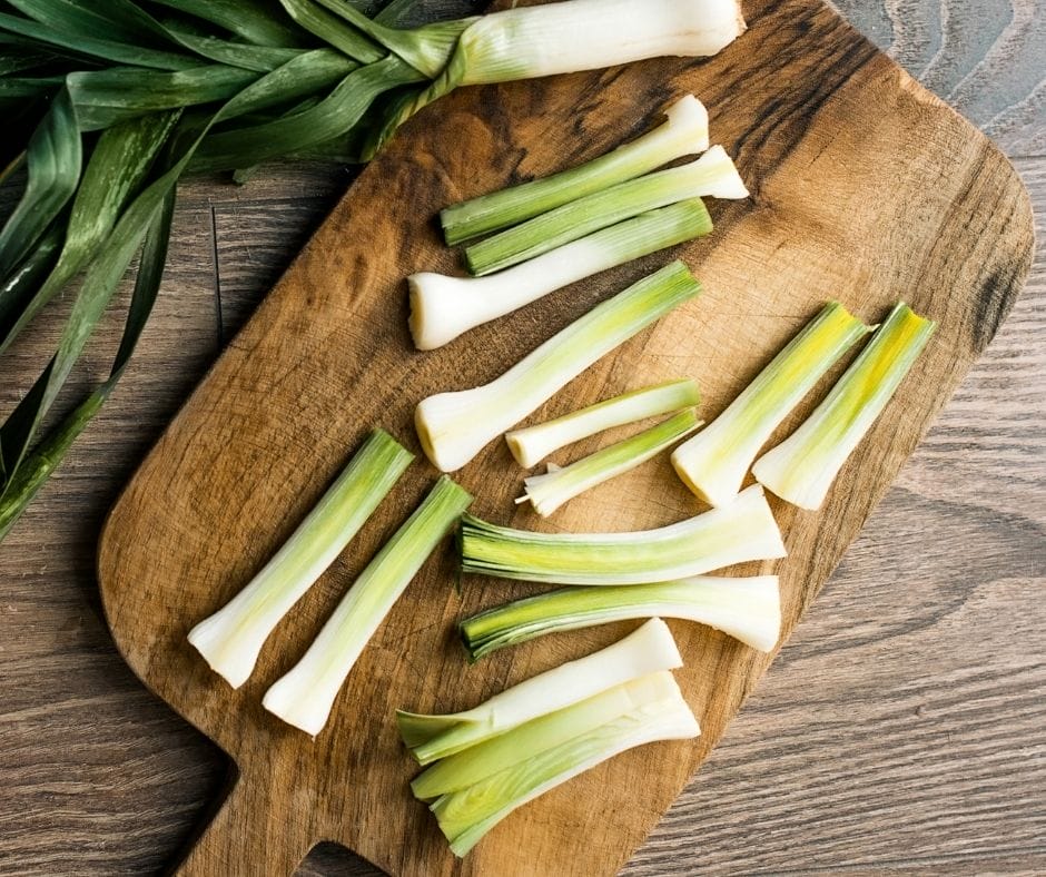 leeks sliced in half long ways on a cutting board