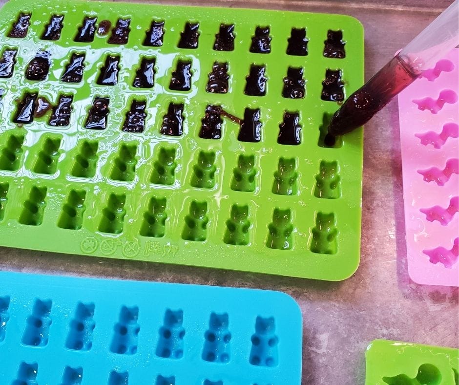 organic elderberry gummies going into silicone molds with droppers