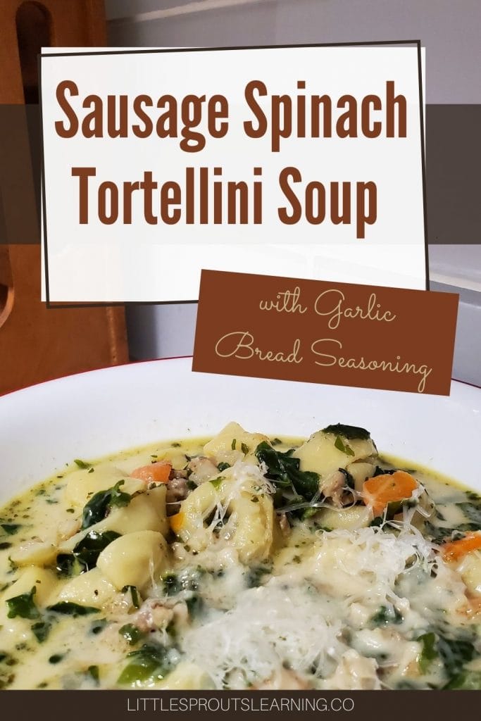 Creamy, comforting sausage spinach tortellini soup topped with shredded parmesan cheese in a bowl on the cabinet