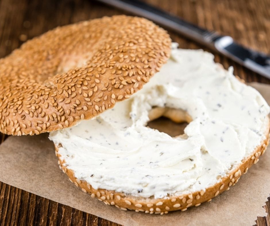 bagel with garlic bread seasoning cream cheese spread on it.