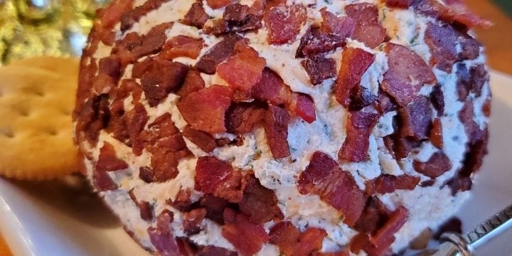 cheese ball covered in bacon bits on a plate