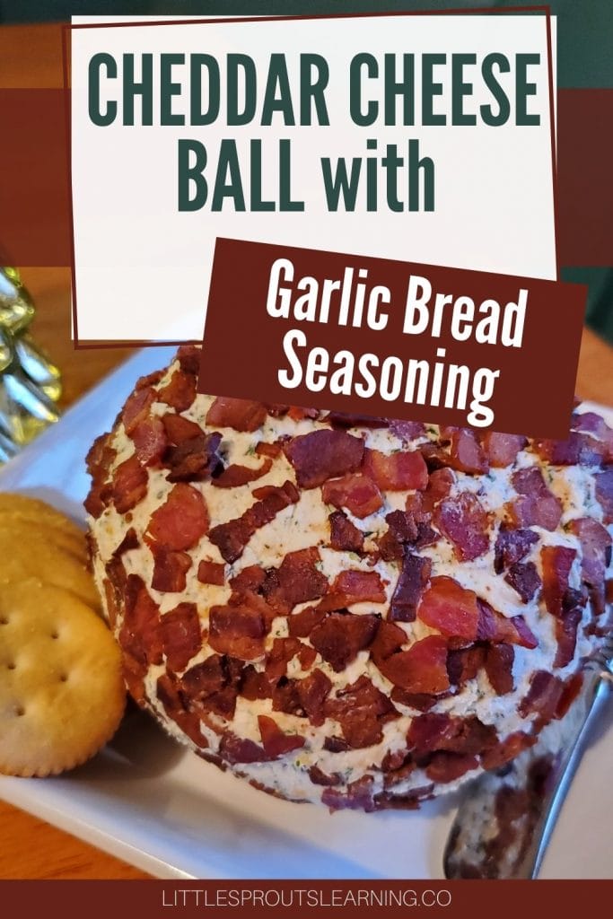 Cheddar cheese ball with garlic bread seasoning mix rolled in bacon on a plte with crackers and a spreader