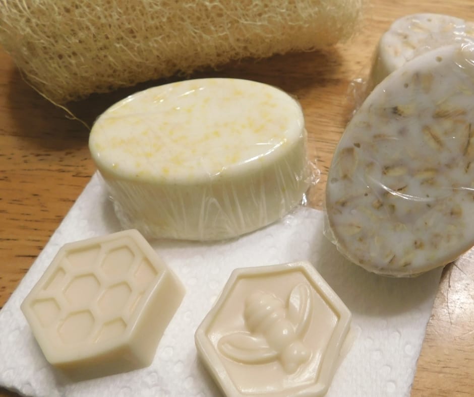 different size and shapes of homemade soaps on the table with a luffa