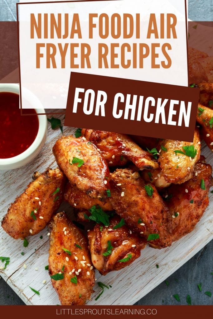 Chicken wings on a plate with sauce on the side.
