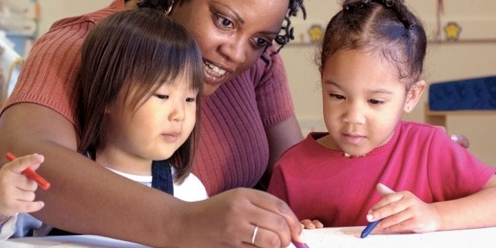 Kids working at a table with a teacher