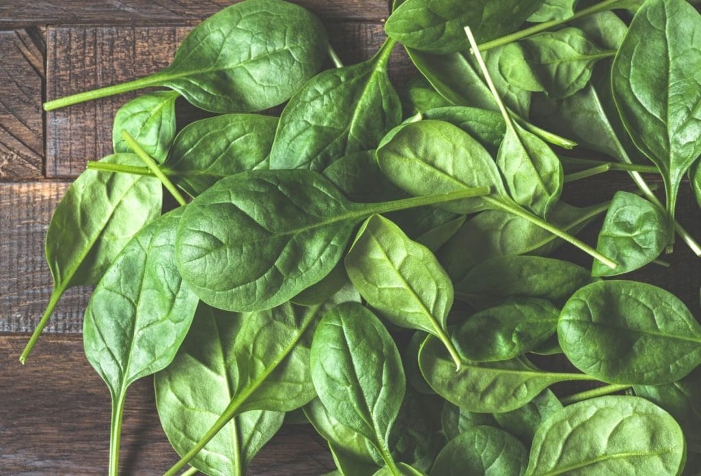 pile of fresh cut spinach on a board