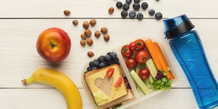 fruits, vegetables, bread, cheese, and nut snacks on a table