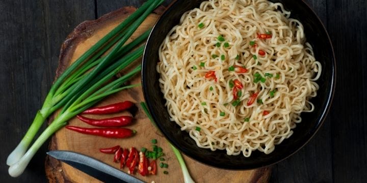 ramen in a bowl with scallions and thai peppers