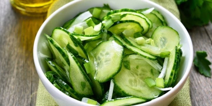 Sliced cucumbers in a bowl with onions