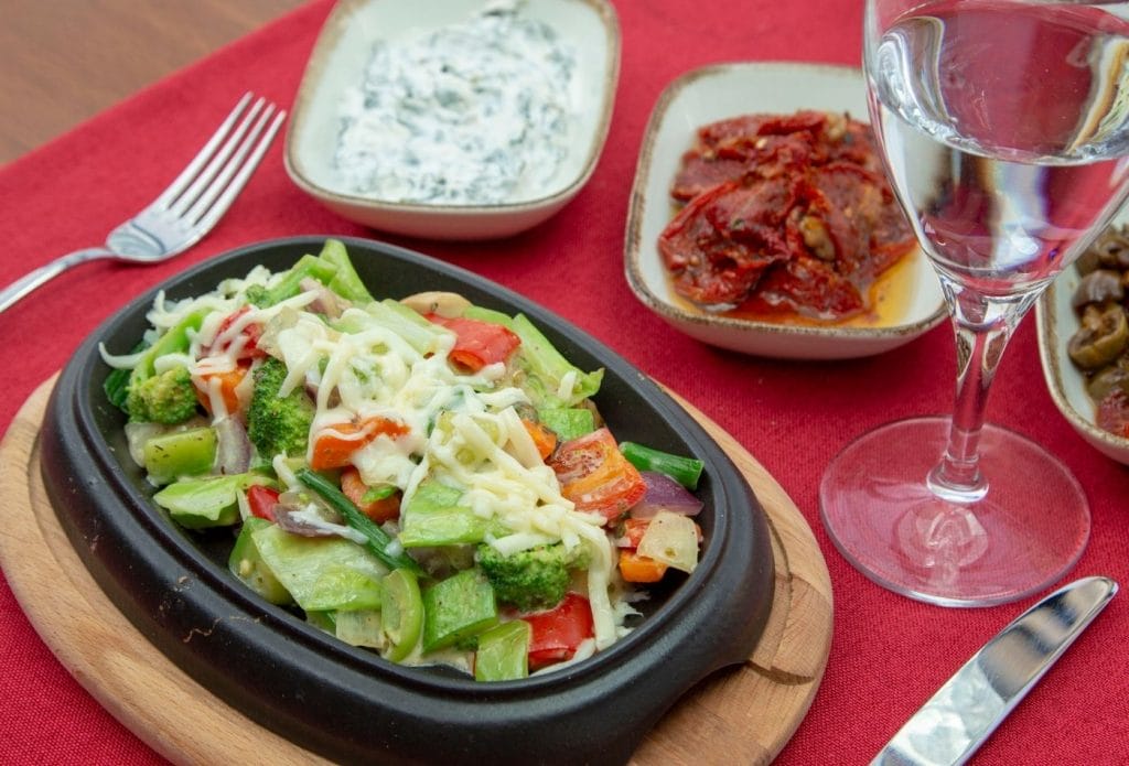 Meatless monday spread of vegetable saute wtih cheese and some sauces on the side