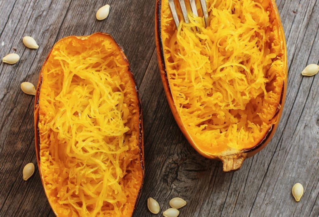 cooked spaghetti squash halves with the meat scraped out and fluffed up