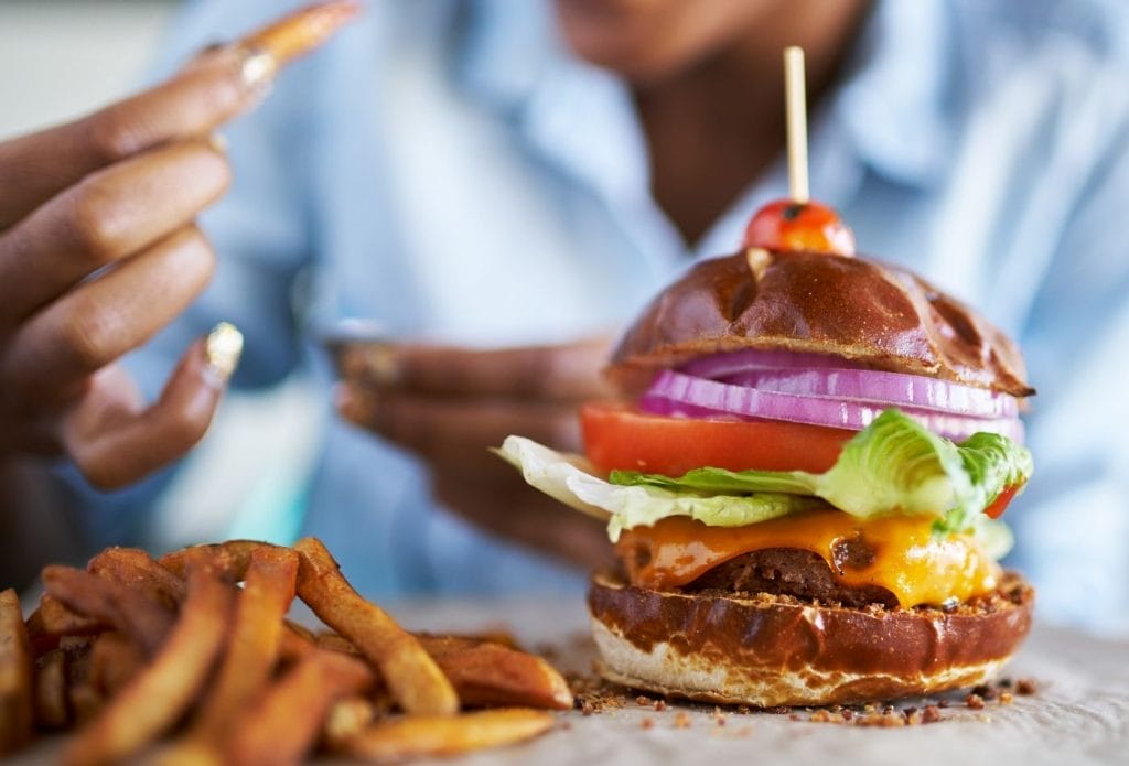 meatless burger on a board with fries