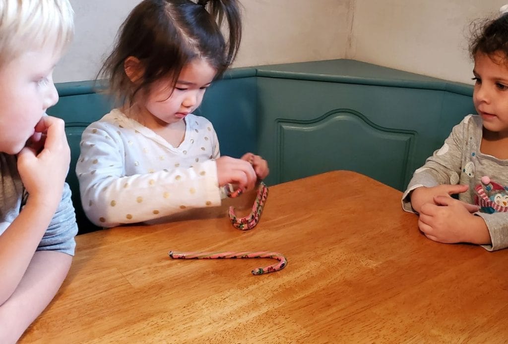 child stacking candy canes on the table