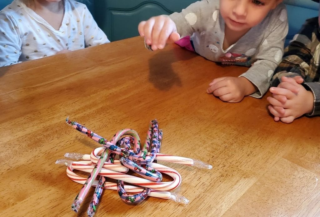 candy canes piled up on the table with kids