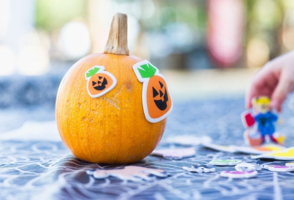 pumpkin decorated with stickers on a tarp