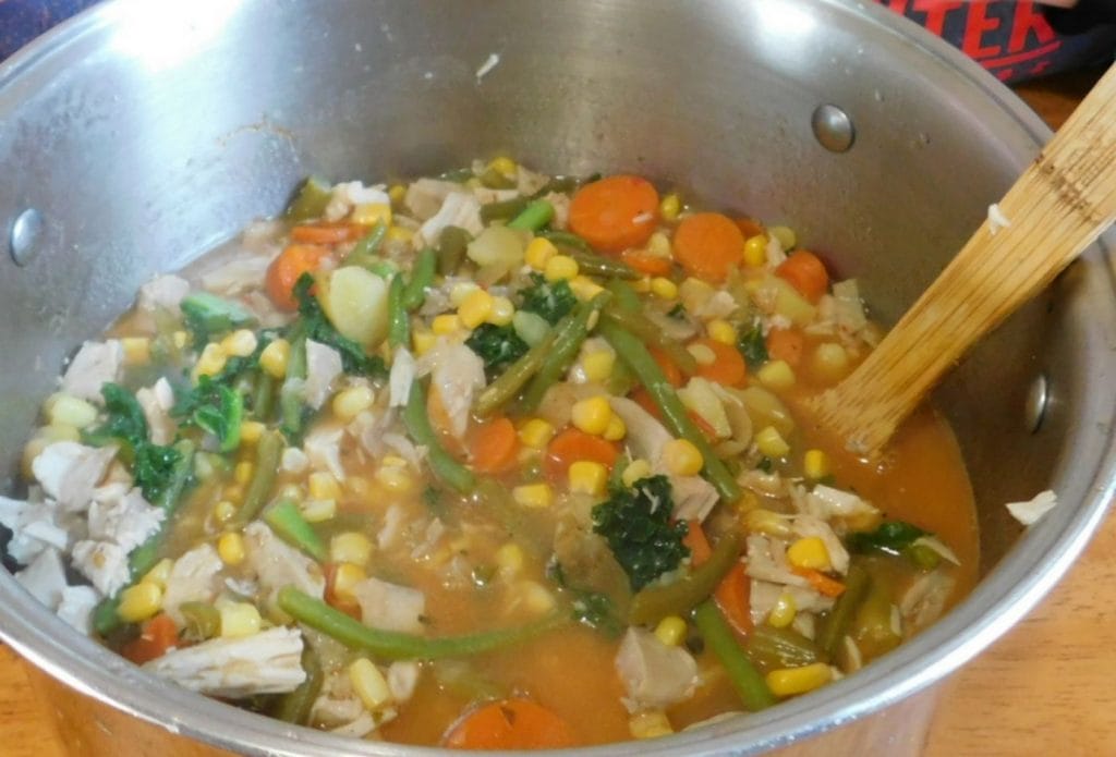 yummy friendship healthy soup made with vegetables shared from kids at daycare. green beans, kale, chicken, corn, carrots and more make it colorful and yummy.