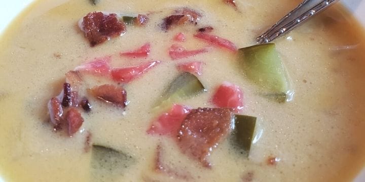 Keto bacon cheeseburger soup in a bow topped with tomatoes, pickles and bacon