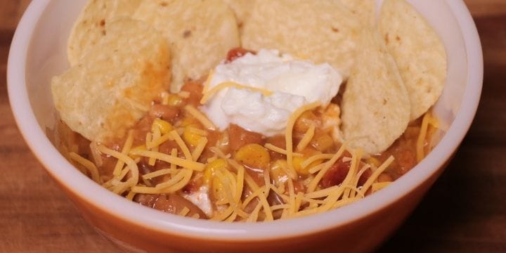 bowl of taco soup meatless meal for picky eaters with cheese, sour cream and chips on top