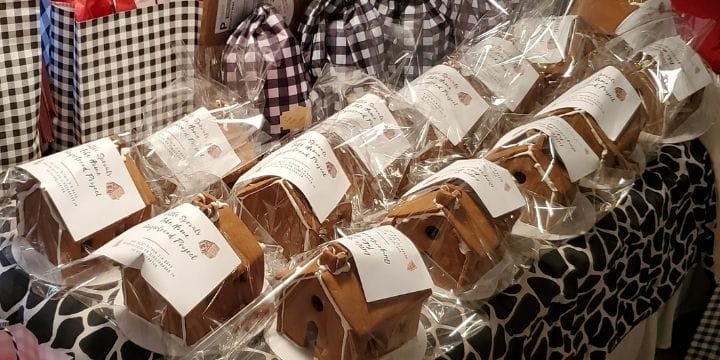 Bags filled with premade gingerbread houses and frosting glue for families to decorate at home