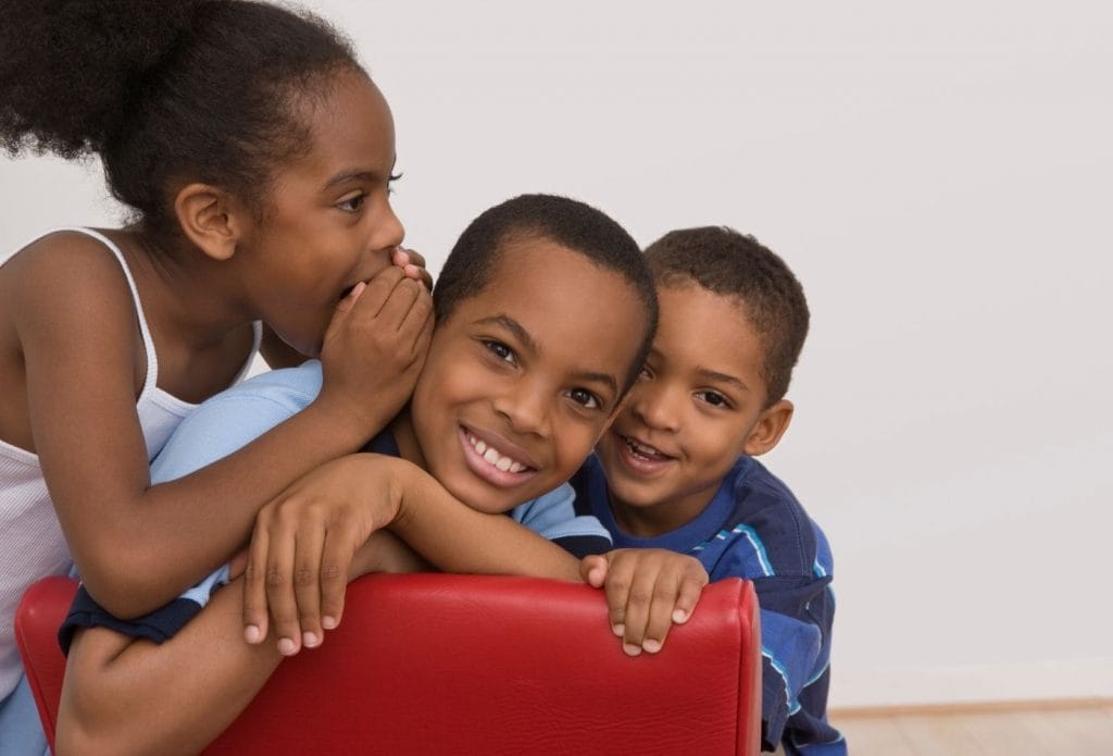 Three kids , mixed age group, climbing on a climber together