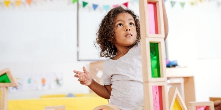 Child in a home daycare stacking blocks in a tower