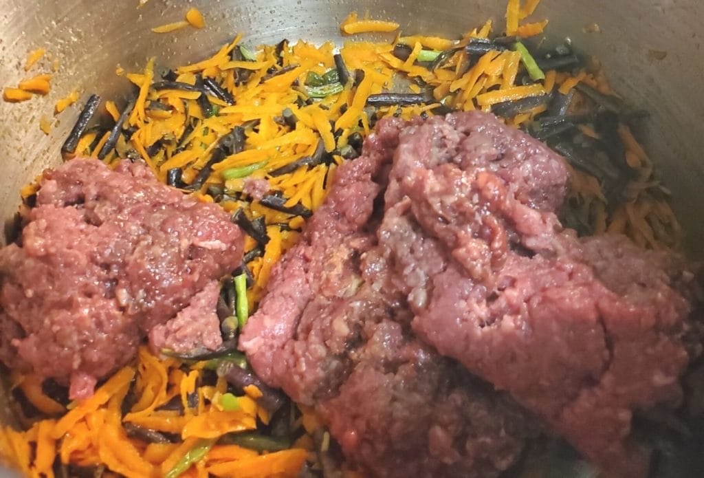 minced beef with carrots and green beans in a stock pot