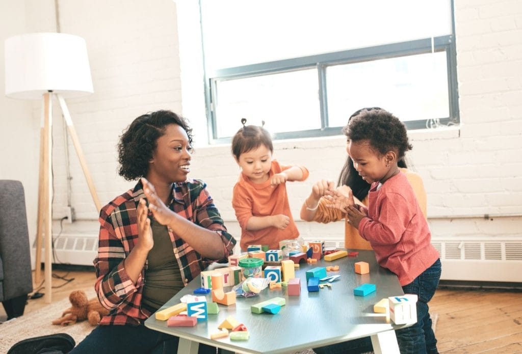 Kids and teacher doing block activity at a table in home daycare