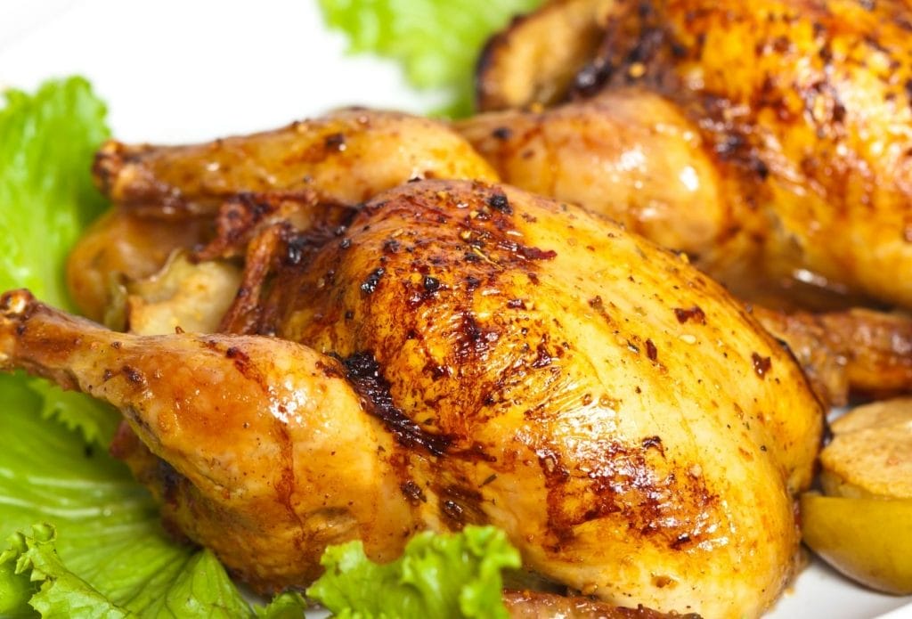 cornish hens on a plate surrounded by lettuce